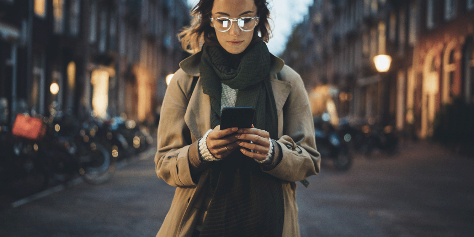 woman looking at phone in city at night