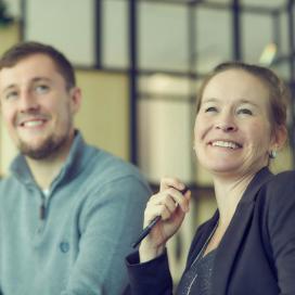 Man and woman smiling in meeting