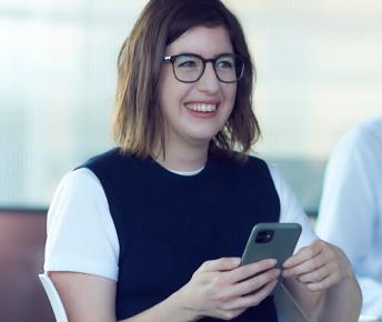 Woman smiling holding mobile phone