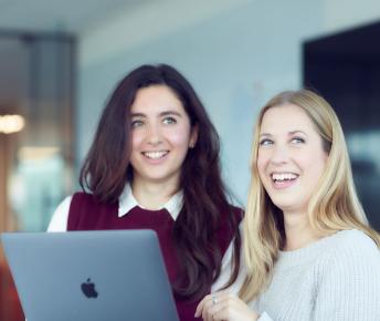 Two women with laptop smiling